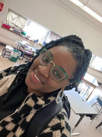 a woman wearing glasses in a classroom